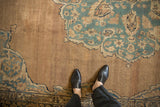 Visible knot heads and foundation on the tea-washed sand field of an antique Kerman carpet.