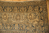 A close-up of the lotus flower and meandering vine border on an antique Kerman carpet.