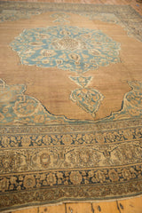 A long view across the lotus flower border of an antique Kerman carpet toward its blue medallion.