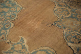 Detail of the antique Kerman's abrashed sand-colored ground showing low pile and exposed knot heads.