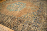 Corner of an antique Kerman carpet with an abrashed field, blue spandrels, and intricate navy borders.