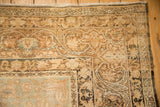 Scrolled vine and palmette border on the worn corner of an antique Kerman carpet.