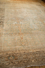 Long view of an antique Kerman rug featuring a time-softened tree of life motif and low pile.