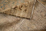Corner of an antique Kerman carpet showing the distressed pile and hand-knotted foundation.