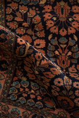 Traditional Persian Sarouk runner with navy ground, dusty coral floral sprays, and palmette border.