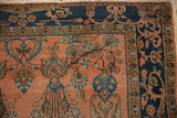 Antique Mohajeran Sarouk rug corner: dusty blush field with floral plants, indigo border.