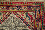 Close-up of the vintage Serab rug's cartouche and pawn design borders in red, green, and blue.