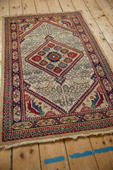 Angled view of a vintage Serab rug with a serrated diamond medallion and geometric borders.