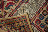 A vintage Serab rug's corner folded over, revealing the hand-knotted construction and woven back.