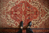 Hand-knotted Malayer rug's ruby red and beige field, sprawling vines, and sapphire accents.