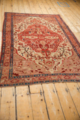 Antique Malayer rug: central ruby red shield medallion, beige field, cypress-like blossoms.