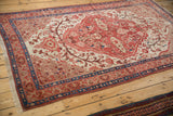 Antique Persian Malayer rug corner, showing sapphire blue and ruby red borders with beige fringe.