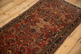 Soft patina on the short wool pile of a vintage Sarouk rug's floral design.