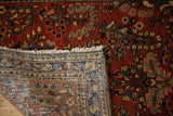 A folded corner of a vintage Sarouk rug revealing its hand-knotted foundation and soft floral pile.