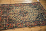 Senneh rug detail: pale brick red geometric border, navy blue Herati field, with mostly even wear.