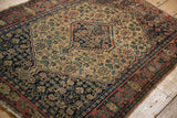 Antique Senneh rug border detail with pale brick red geometric vine motif and navy blue outer edge, showing wear.