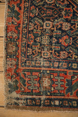 Worn corner of antique Senneh rug with exposed foundation and geometric border in red, navy.
