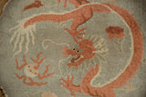 Textured pile of an antique Art Deco rug showing a pictorial terracotta dragon and visible foundation.
