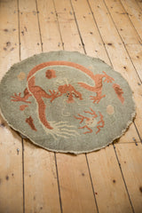Angled perspective of the antique Chinese Art Deco round rug with its terracotta dragon motif.