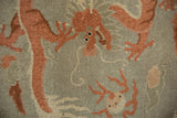 Hand-knotted texture and low pile showing a five-toed dragon in pale terracotta tones.