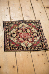 Angled view of the antique Persian Yezd mat, emphasizing its square form and central medallion.