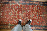 A vintage Lilihan rug from overhead, showing the abrashed texture of its red field and floral design.