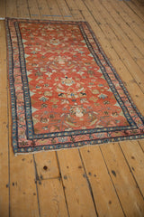 Angled view of a vintage Lilihan rug with an abrashed cranberry field and detailed floral palmettes.