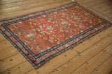 Vintage Persian Lilihan rug with a cranberry red allover pattern, viewed from a high angle down its length.