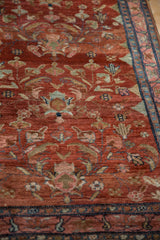 Angled perspective of a vintage Lilihan rug, showing detailed palmettes on an abrashed red field.