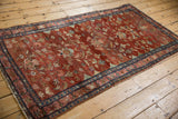 Angled view of a vintage Lilihan rug with an abrashed red field and dense allover floral design.