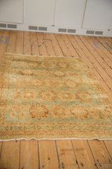 A vintage distressed Afshar rug from a high angle, showing its decorative, repeating medallion field.