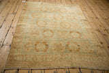 Angled view of a vintage Afshar rug with soft sea foam and coffee brown medallions.