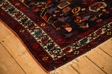 Corner detail of a vintage Bakhtiari rug showing the hand-knotted pile and intricate geometric border.
