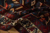 Close-up on the dense wool pile and rich color nuances of a vintage Persian Bakhtiari carpet.