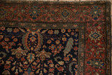 Madder red palmette and meandering vine border on an antique Persian Farahan Sarouk rug corner.