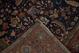 Reverse view of a hand-knotted Persian rug showing the foundation weave and remnants of an older pad.