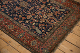 Antique Farahan Sarouk rug corner showing the navy field beside the intricate madder red palmette border.
