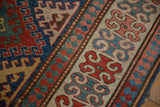 Antique Kazak rug detail: sapphire blue, madder red geometric pawn and floral borders.