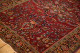 Angled view of the textured low pile and dense floral sprays on a vintage Persian Sarouk rug.