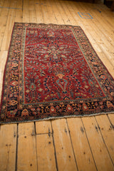 Angled view of a vintage Sarouk rug highlighting its starburst medallion and floral field.