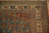Worn side border of the antique Bijar rug, displaying geometric motifs in dusty teal, burgundy, and beige.