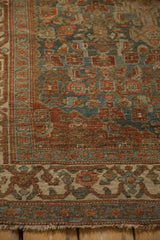 Abrashed texture and geometric border motifs in dusty teal and burgundy on the antique Bijar rug.