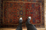 Overhead view of an antique Farahan Sarouk rug, showing the scale of its allover gem-toned pattern.