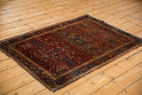 Antique Farahan Sarouk rug featuring a dense floral pattern in ruby red and sapphire blue.