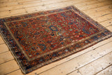 Antique Farahan Sarouk rug showing its gem-toned allover design from a perspective view.