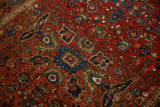 Detail of an antique Farahan Sarouk showing gem-toned floral motifs and textured wear to the knot heads.