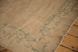 Antique Chinese Peking rug corner showcasing seafoam green scrolling tendril and original selvage.