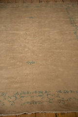 Aged beige pile and seafoam green scrolling floral border detail on this antique Chinese Peking rug.