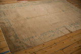 Antique Peking rug's seafoam green scrolling tendril border on a beige field with intact selvage.
