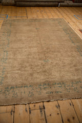 Edge of an antique Peking rug showcasing the seafoam green floral border and secured selvage.